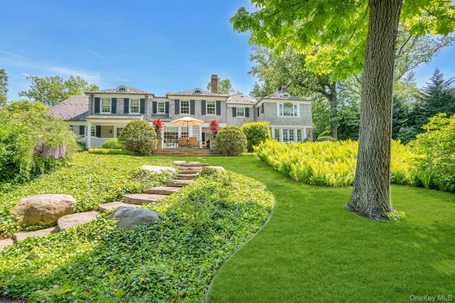 a view of swimming pool that has lawn chairs with plants and trees