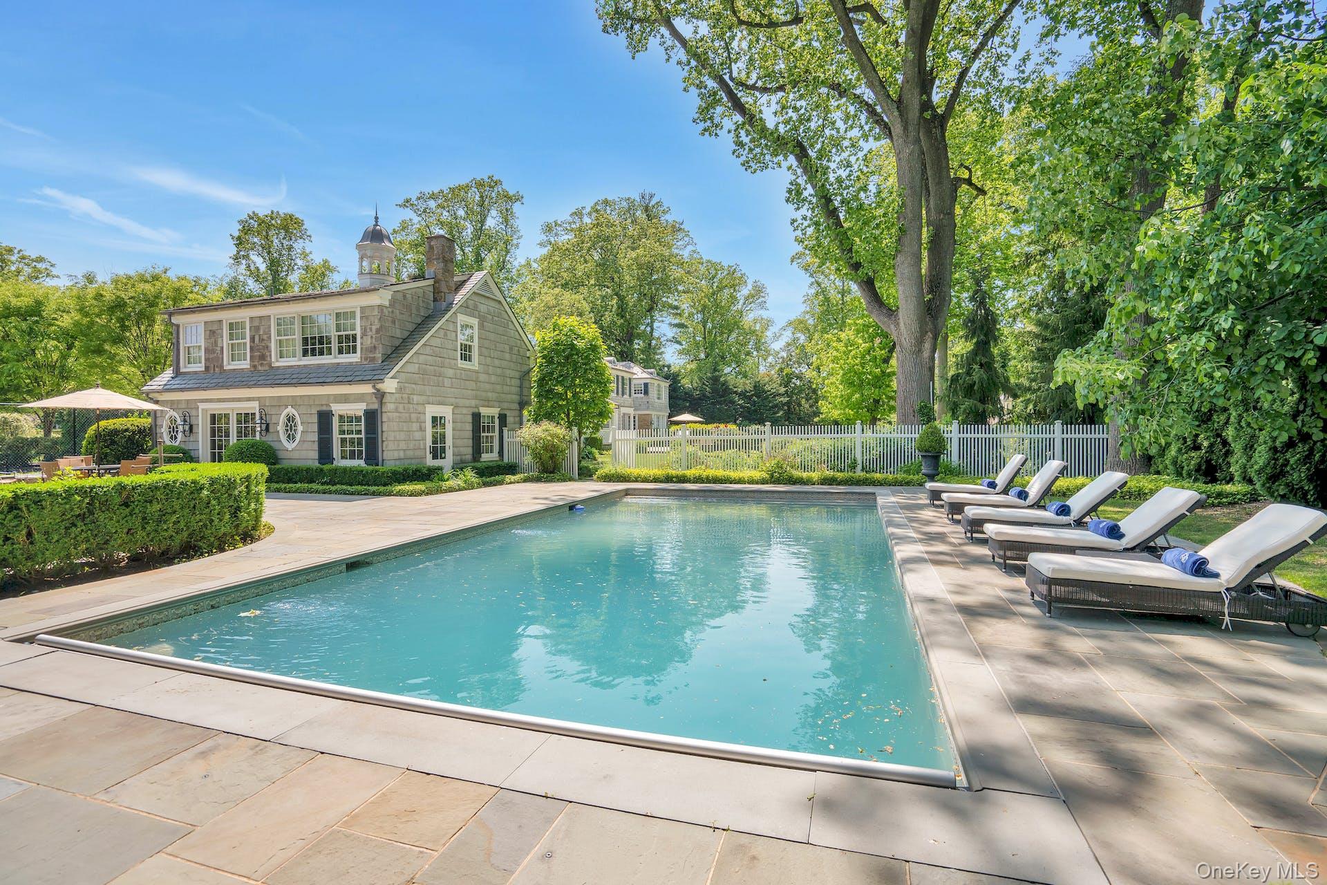 191 Elderfields Road Manhasset, NY 11030 - Photo 27 of 34 a view of swimming pool that has lawn chairs with plants and trees
