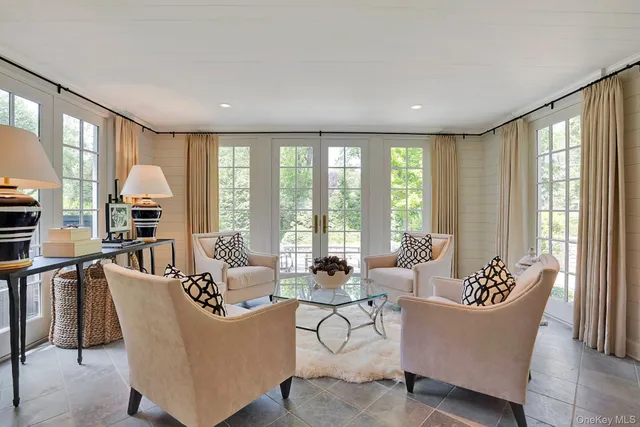 a living room with furniture a fireplace and a floor to ceiling window