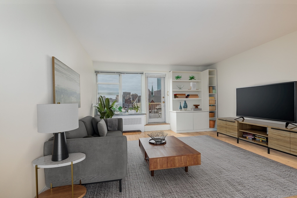 145 Pinckney Street, Unit 719 Boston, MA 02114 - Photo 1 of 11 a living room with furniture and a flat screen tv
