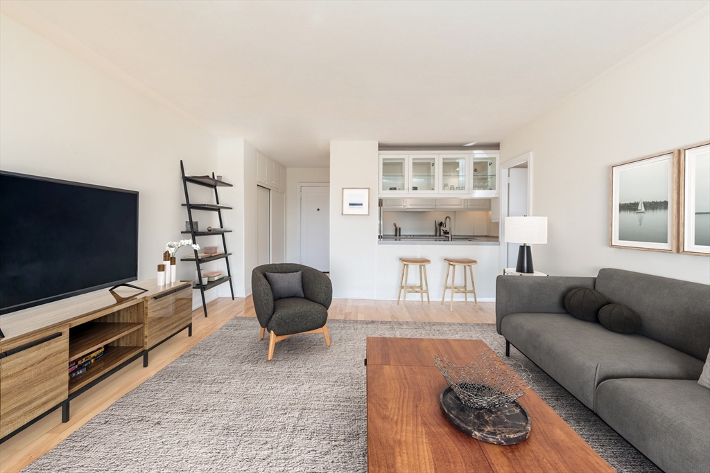 145 Pinckney Street, Unit 719 Boston, MA 02114 - Photo 2 of 11 a living room with furniture and a flat screen tv