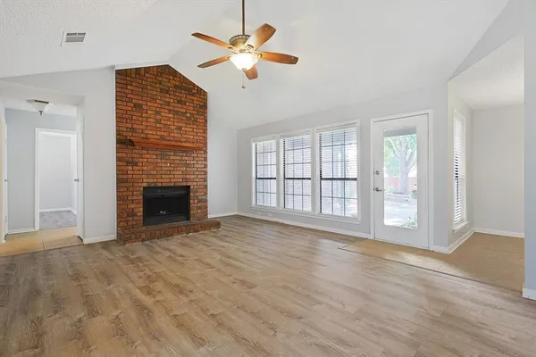 a view of an empty room with a fireplace and a window