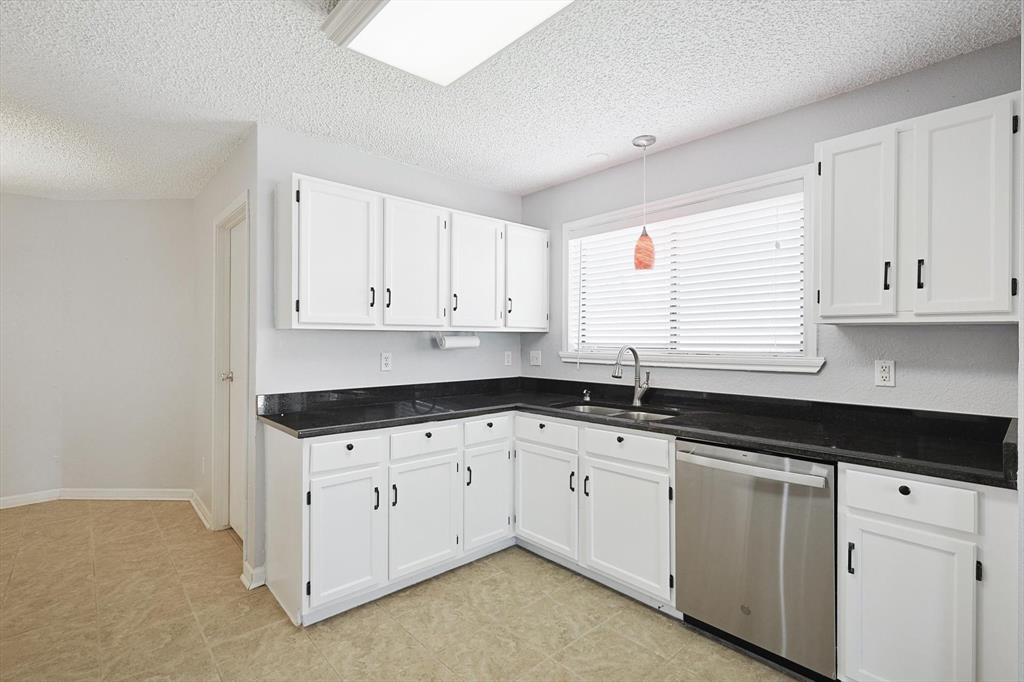 266 Pinyon Lane Coppell, TX 75019 - Photo 7 of 20 a kitchen with granite countertop white cabinets sink and dishwasher