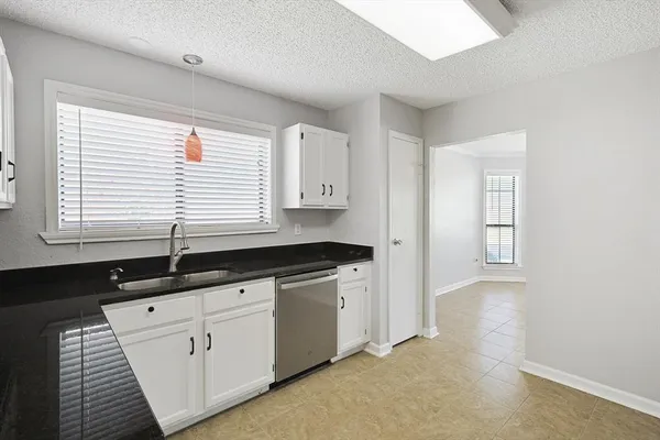 a kitchen with granite countertop a sink and a stove