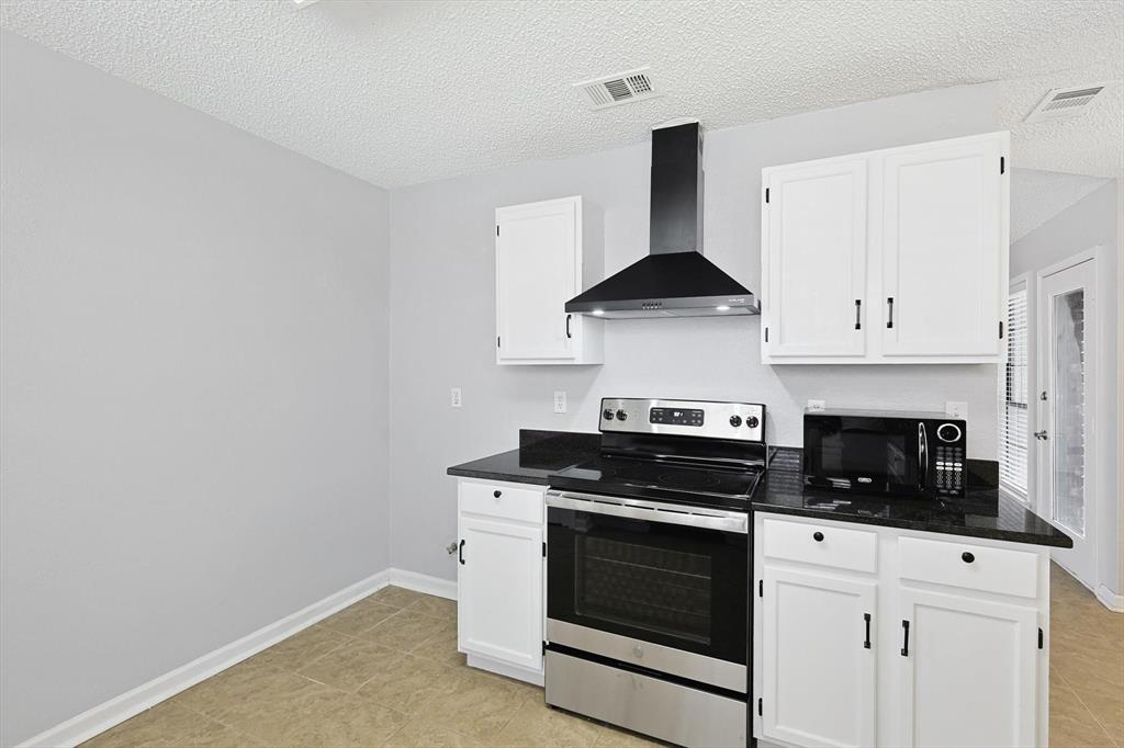 266 Pinyon Lane Coppell, TX 75019 - Photo 9 of 20 a kitchen with stainless steel appliances a stove and white cabinets