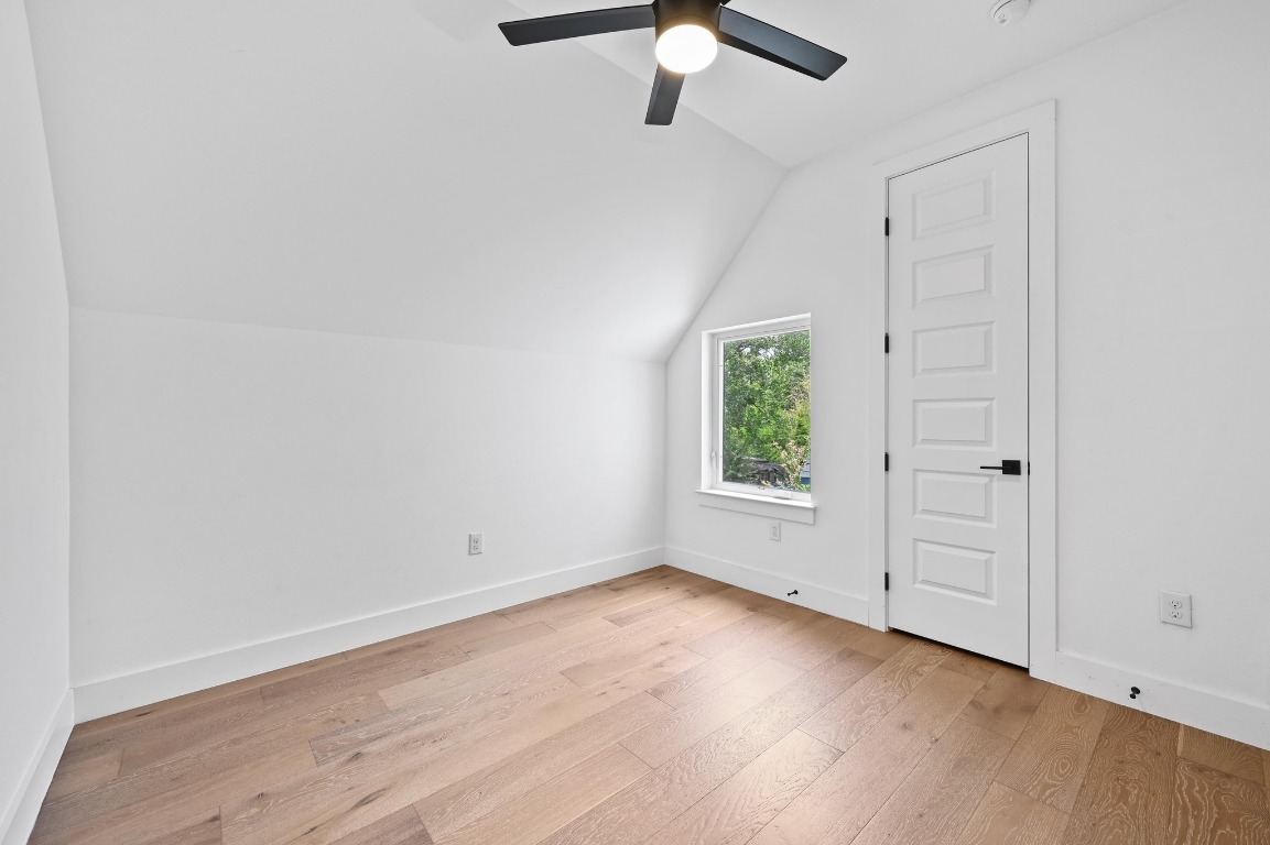 504 Normandy Street, Unit A Austin, TX 78745 - Photo 12 of 20 an empty room with wooden floor cabinet and windows