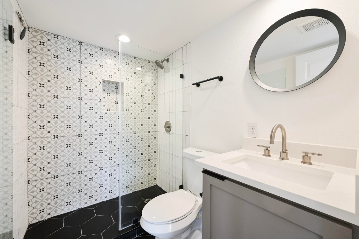 504 Normandy Street, Unit A Austin, TX 78745 - Photo 18 of 20 a bathroom with a sink toilet and a mirror