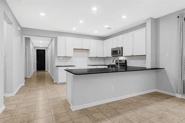 a kitchen with stainless steel appliances granite countertop a sink and a stove