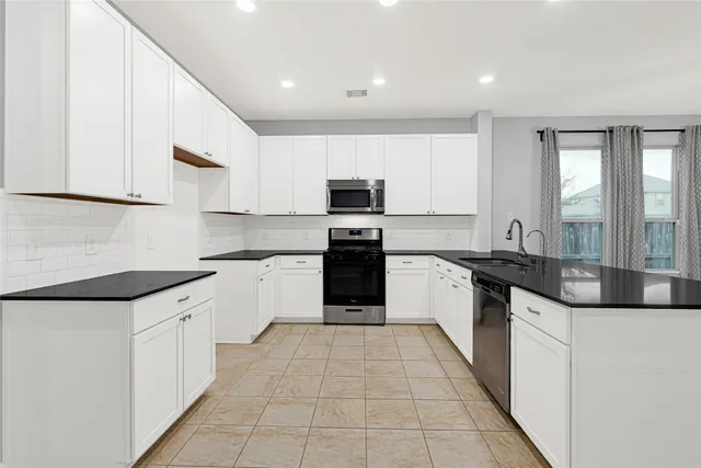 a large kitchen with a stove top oven and cabinets