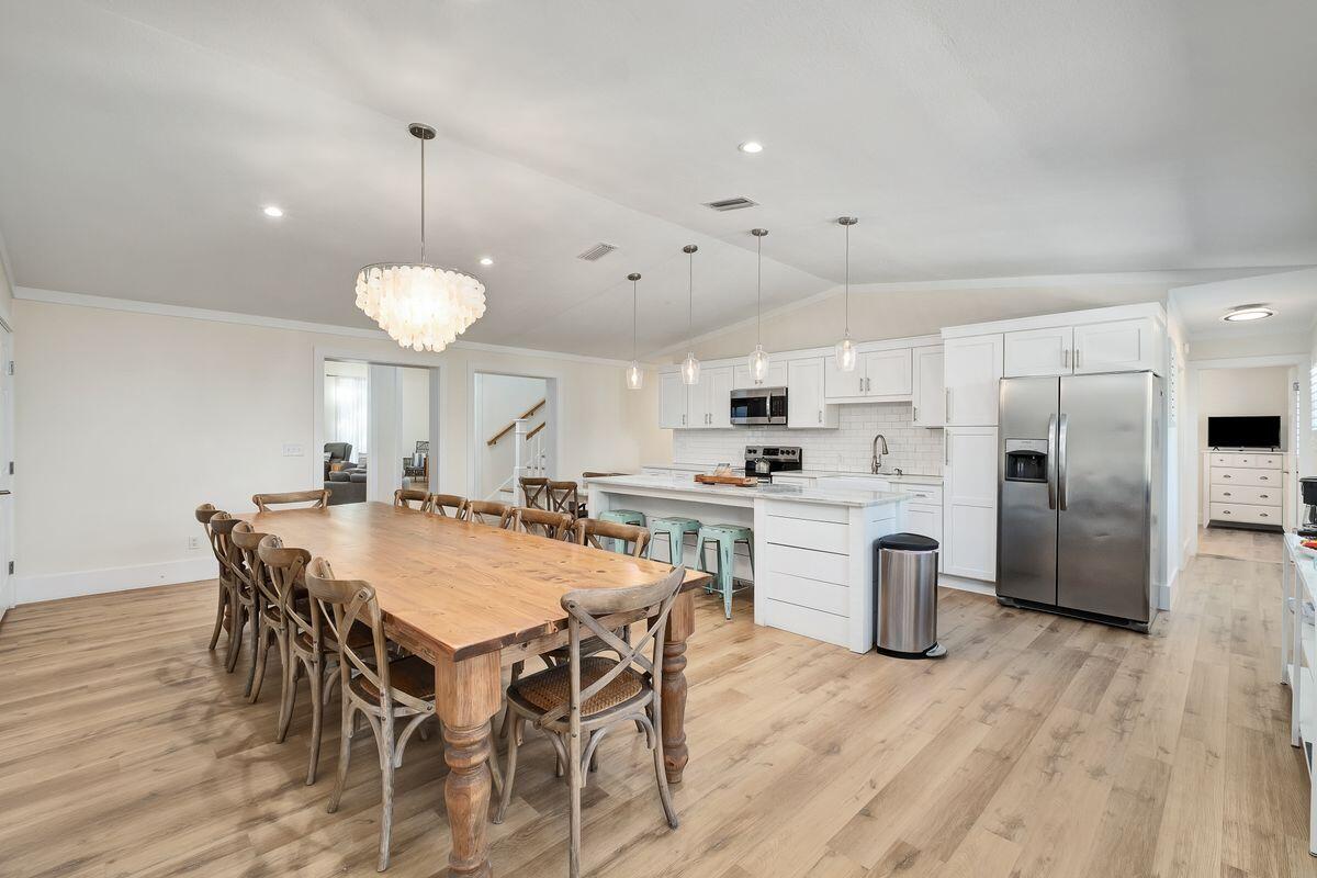 251 Dogwood Street Santa Rosa Beach, FL 32459 - Photo 13 of 51 a kitchen with stainless steel appliances kitchen island granite countertop a dining table chairs and white cabinets