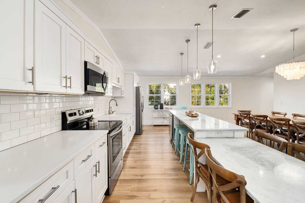 251 Dogwood Street Santa Rosa Beach, FL 32459 - Photo 17 of 51 a kitchen with stainless steel appliances a stove a sink a microwave a center island and a window