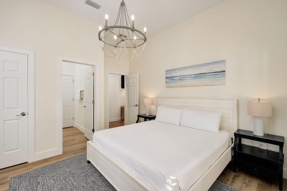 251 Dogwood Street Santa Rosa Beach, FL 32459 - Photo 30 of 51 a bedroom with a bed and a chandelier