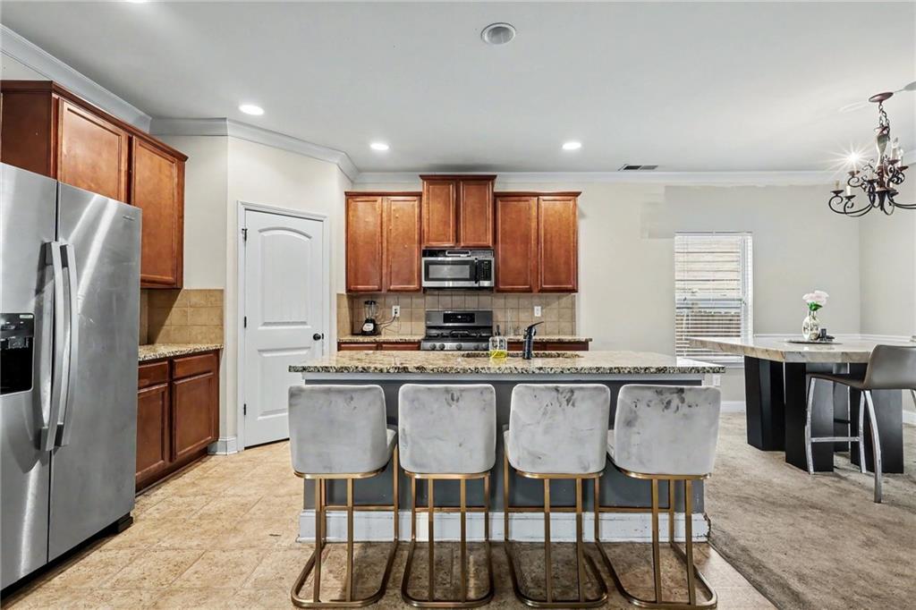 2780 Lakeview Walk Decatur, GA 30035 - Photo 10 of 37 a kitchen with stainless steel appliances granite countertop a dining table chairs refrigerator and microwave