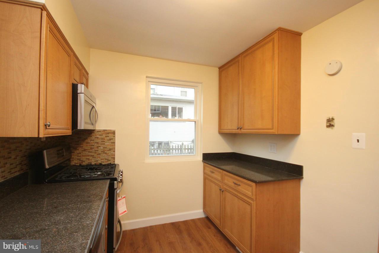 1901 North Quebec Street, Unit MIDDLE Arlington, VA 22207 - Photo 11 of 21 a kitchen with granite countertop cabinets stainless steel appliances a sink and a window