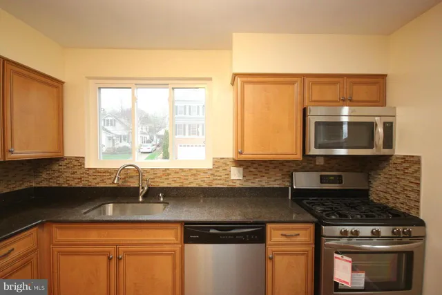 a kitchen with stainless steel appliances granite countertop a sink a stove and a microwave