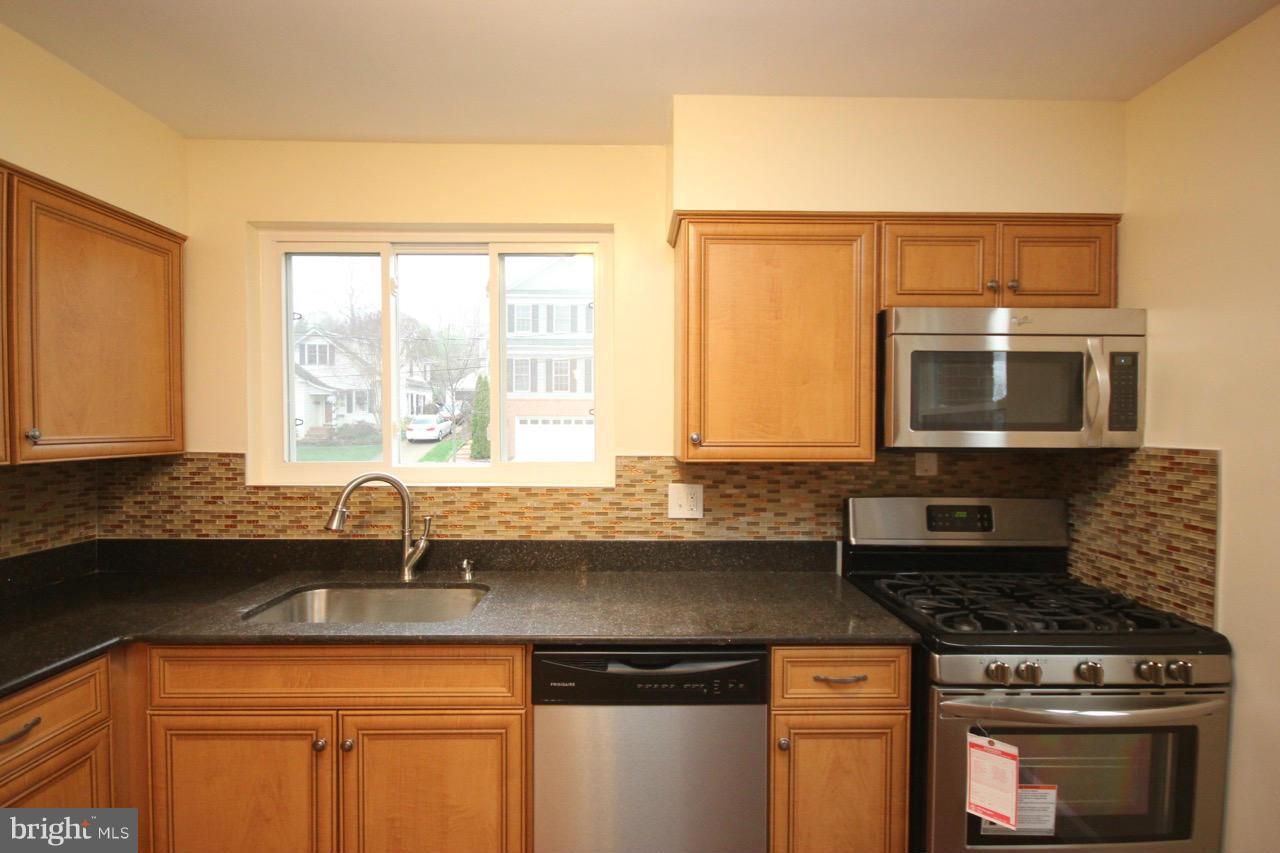 1901 North Quebec Street, Unit MIDDLE Arlington, VA 22207 - Photo 12 of 21 a kitchen with stainless steel appliances granite countertop a sink a stove and a microwave