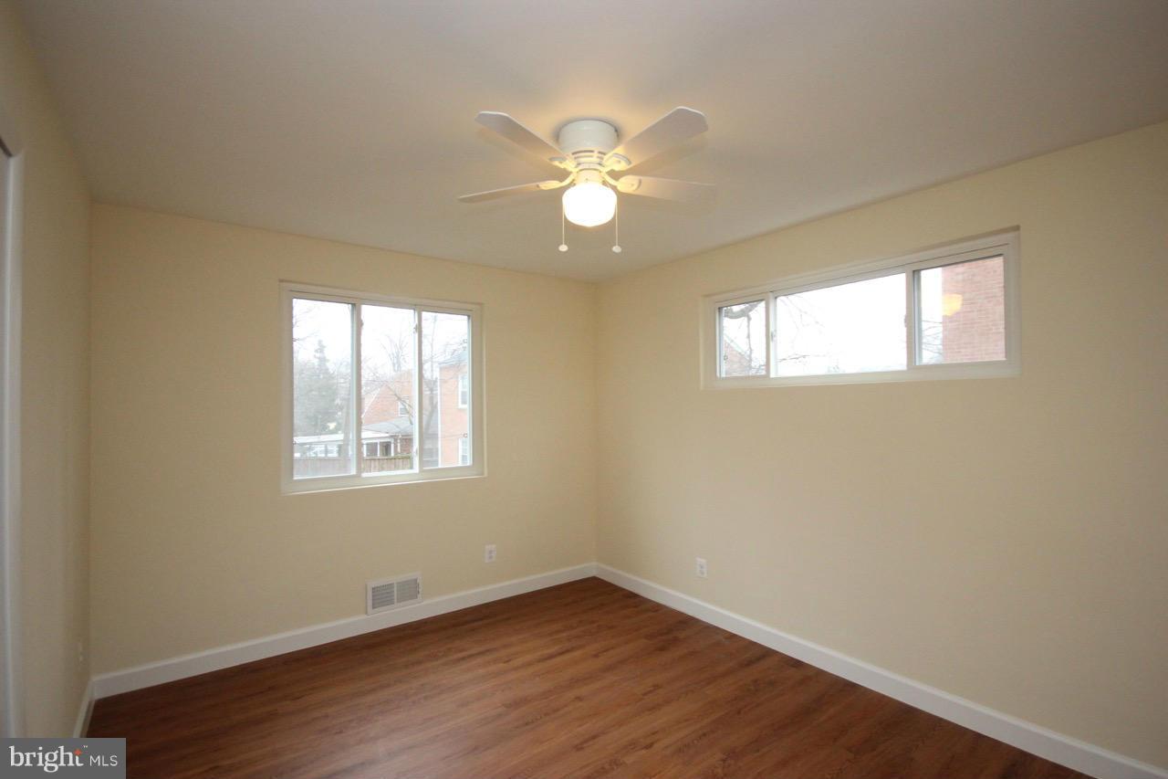 1901 North Quebec Street, Unit MIDDLE Arlington, VA 22207 - Photo 18 of 21 a view of an empty room with wooden floor and a window