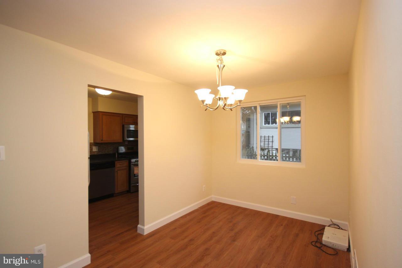 1901 North Quebec Street, Unit MIDDLE Arlington, VA 22207 - Photo 8 of 21 wooden floor in an empty room with a window