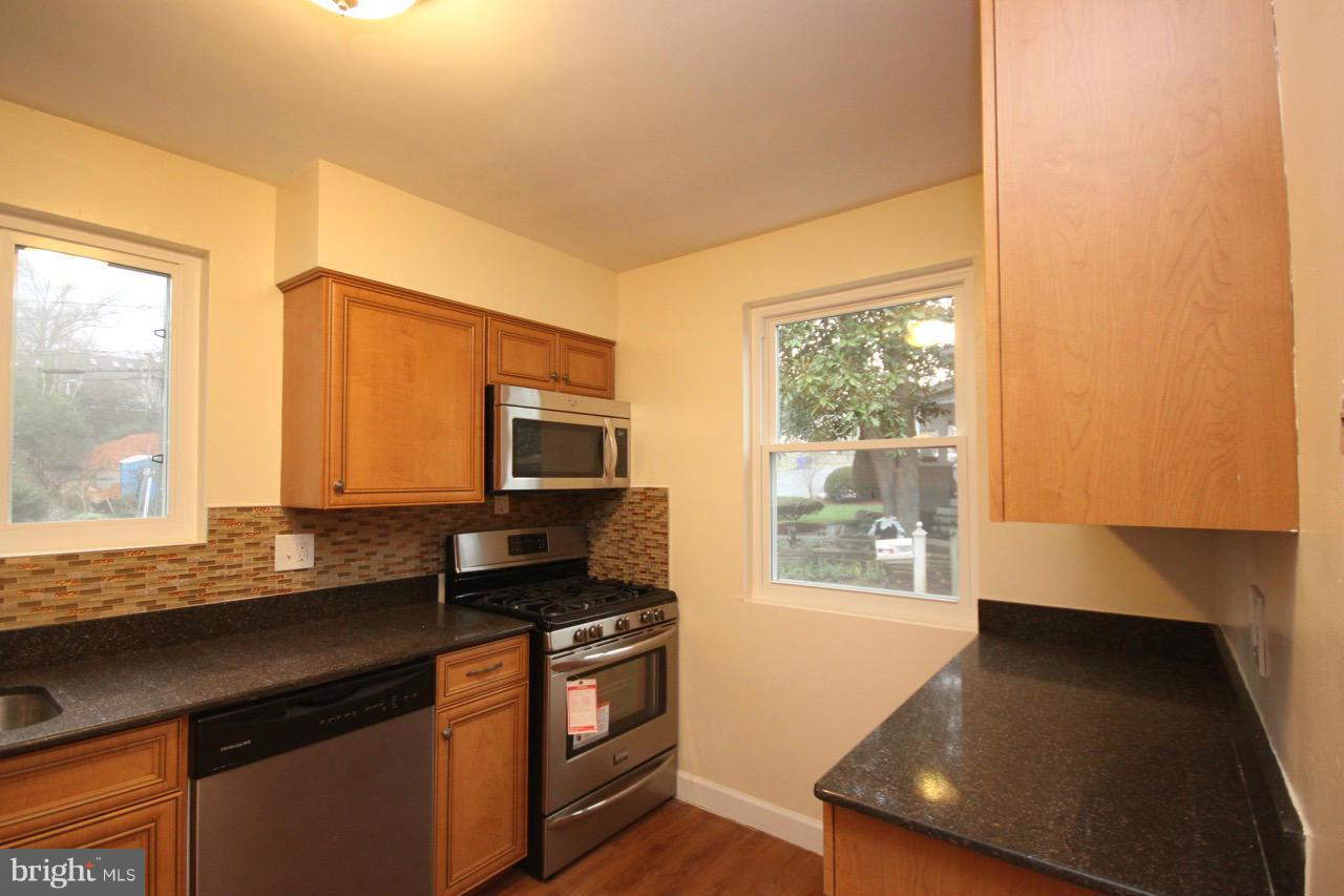 1901 North Quebec Street, Unit MIDDLE Arlington, VA 22207 - Photo 9 of 21 a kitchen with stainless steel appliances granite countertop a stove a sink and a microwave