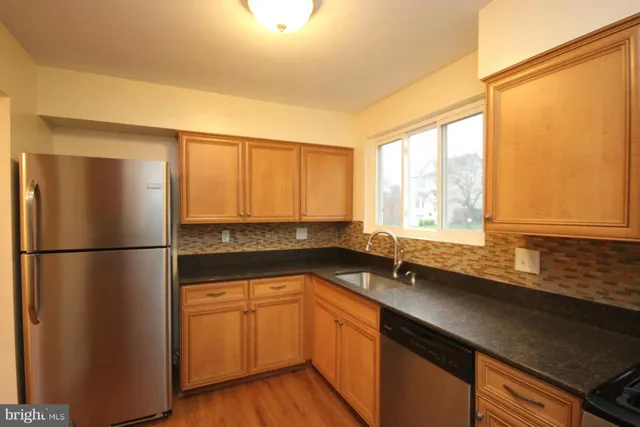 a kitchen with a sink a refrigerator and cabinets
