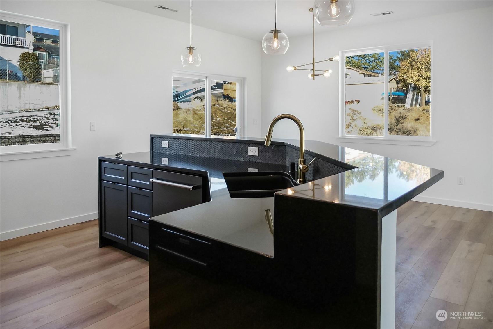 431 Strand Road Ephrata, WA 98823 - Photo 29 of 39 a kitchen with a kitchen island wooden floor and black appliances