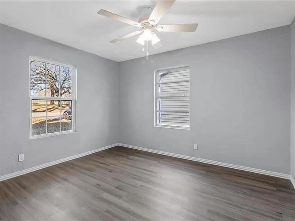 732 East Morton Street Denison, TX 75021 - Photo 12 of 14 an empty room with wooden floor chandelier fan and windows