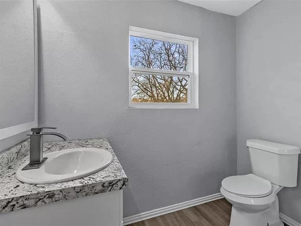 732 East Morton Street Denison, TX 75021 - Photo 8 of 14 a bathroom with a toilet sink and mirror