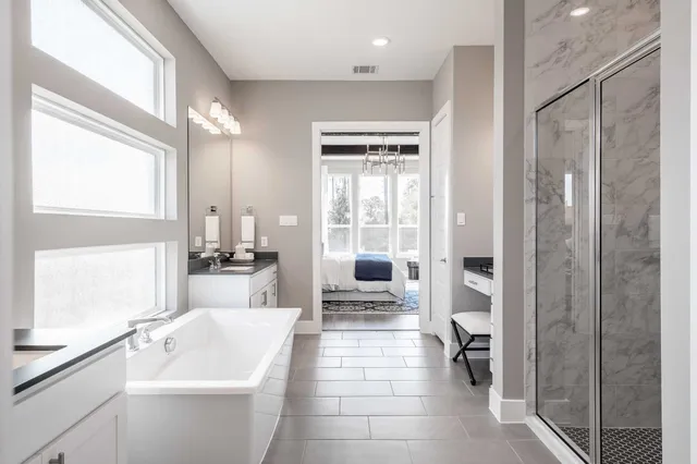 a bathroom with a tub sink shower and mirror