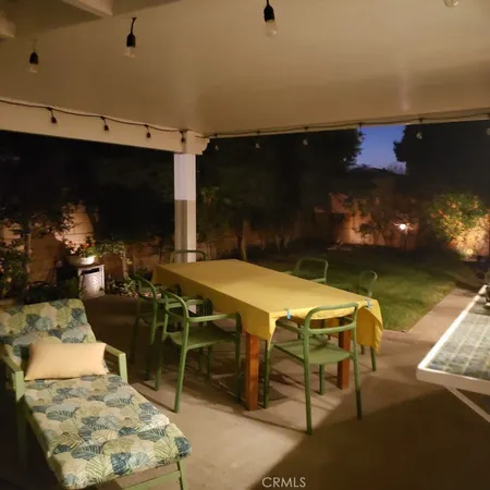 a patio with table and chairs with potted plants