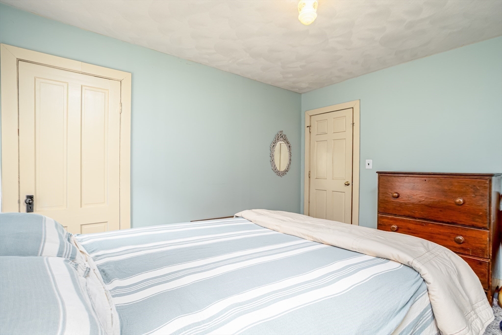 216 Dunstable Road North Chelmsford, MA 01863 - Photo 21 of 42 a bedroom with a bed and a chandelier