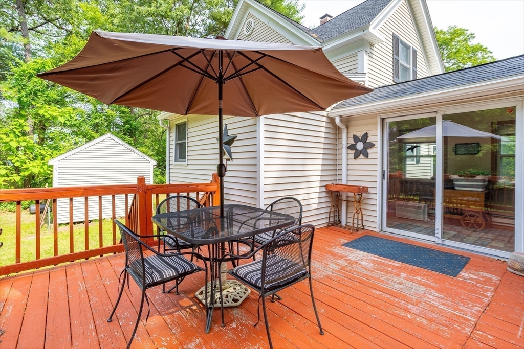 216 Dunstable Road North Chelmsford, MA 01863 - Photo 33 of 42 a patio with wooden floor a yard a table and chairs