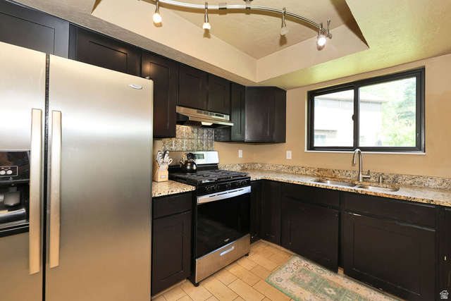 3104 East High Danish Road Sandy, UT 84093 - Photo 10 of 36 Kitchen featuring dark cabinetry, stainless steel appliances, granite-style countertops, and a tile backsplash