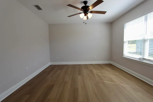 a view of a room with wooden floor and a window