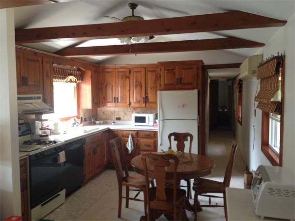 17 Adams Road Sturbridge, MA 01566 - Photo 9 of 25 a kitchen with a table chairs refrigerator and cabinets