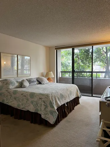 a bedroom with a bed and large windows