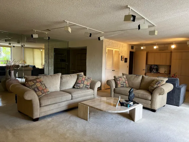 a living room with furniture and a large mirror