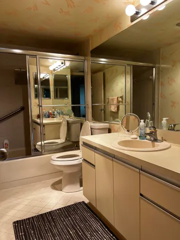 a bathroom with a sink a toilet and shower