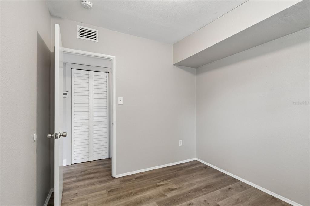 9228 82nd Way Seminole, FL 33777 - Photo 17 of 35 an empty room with wooden floor closet and windows