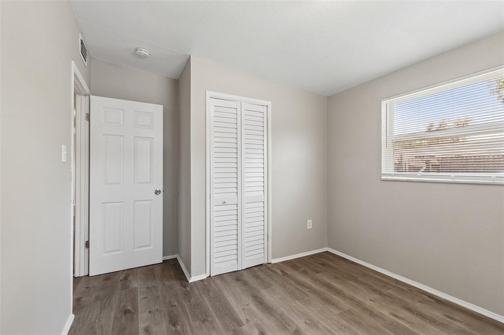 9228 82nd Way Seminole, FL 33777 - Photo 20 of 35 an empty room with wooden floor and windows