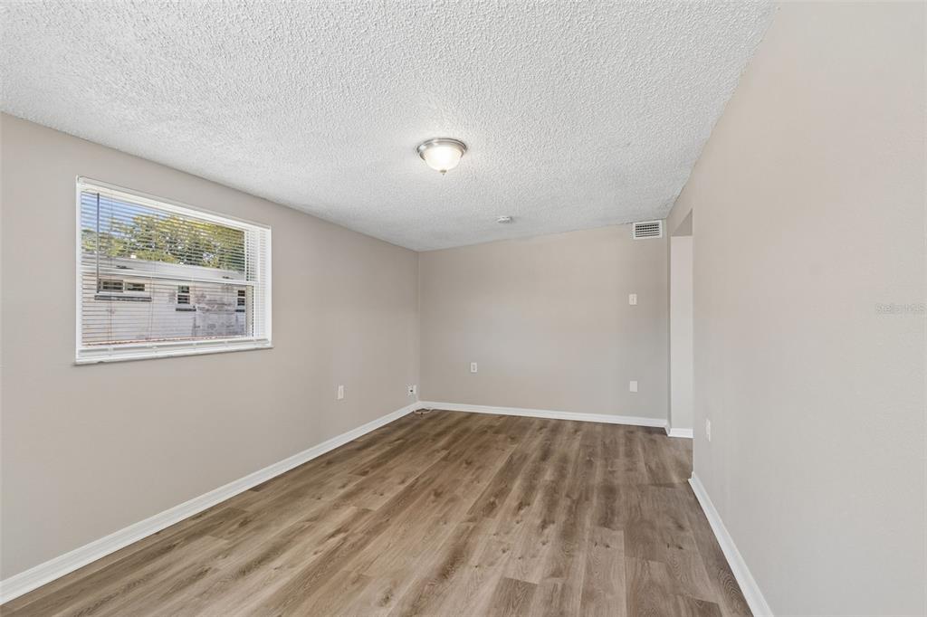 9228 82nd Way Seminole, FL 33777 - Photo 27 of 35 an empty room with wooden floor and windows