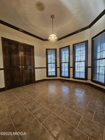 a view of an empty room with closet and a window