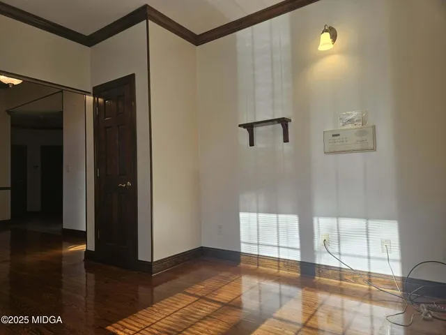 a view of an empty room with kitchen and a window