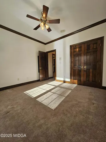 a view of an empty room with a ceiling fan