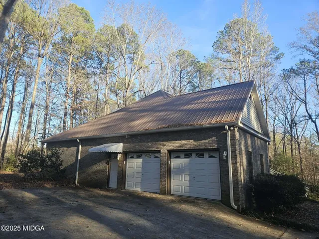 a view of backyard with large trees and wooden fence