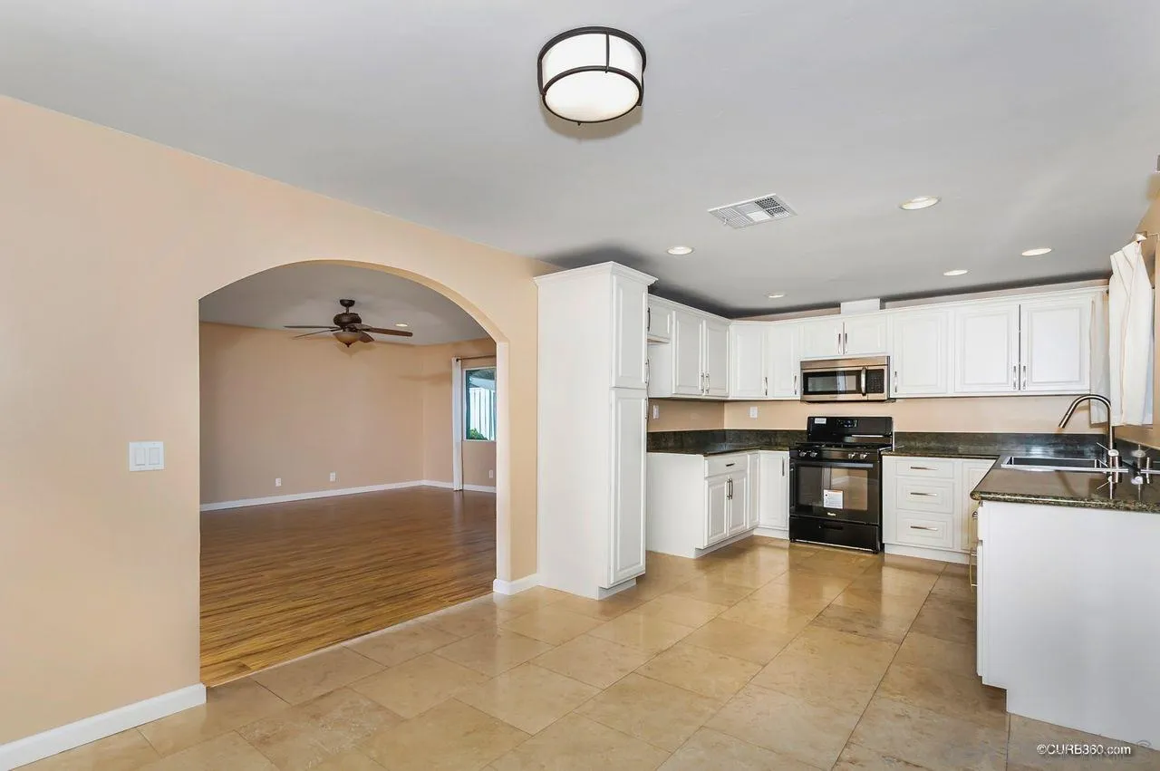 13513 Carriage Road Poway, CA 92064 - Photo 5 of 18 a kitchen with stainless steel appliances granite countertop a stove a sink and a refrigerator