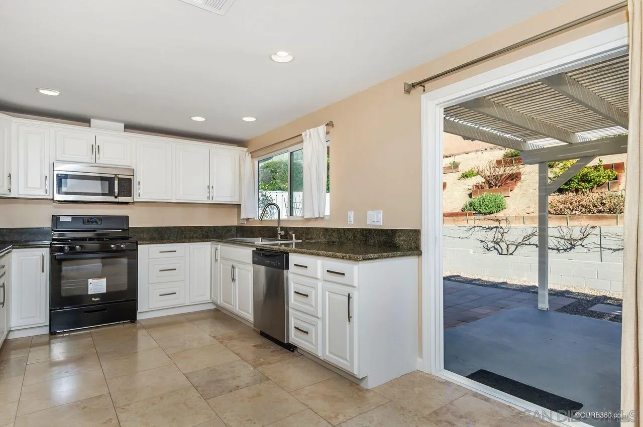 13513 Carriage Road Poway, CA 92064 - Photo 6 of 18 a kitchen with stainless steel appliances granite countertop a stove a sink and a refrigerator