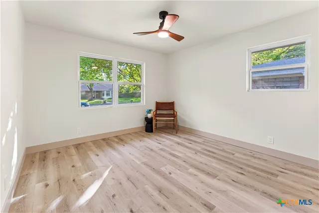 a view of a room with wooden floor and a window