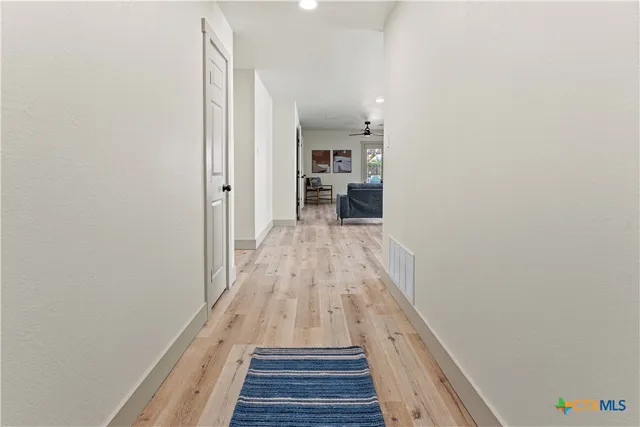 a view of a hallway with wooden floor and staircase