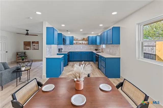 a kitchen with stainless steel appliances granite countertop a sink and a refrigerator