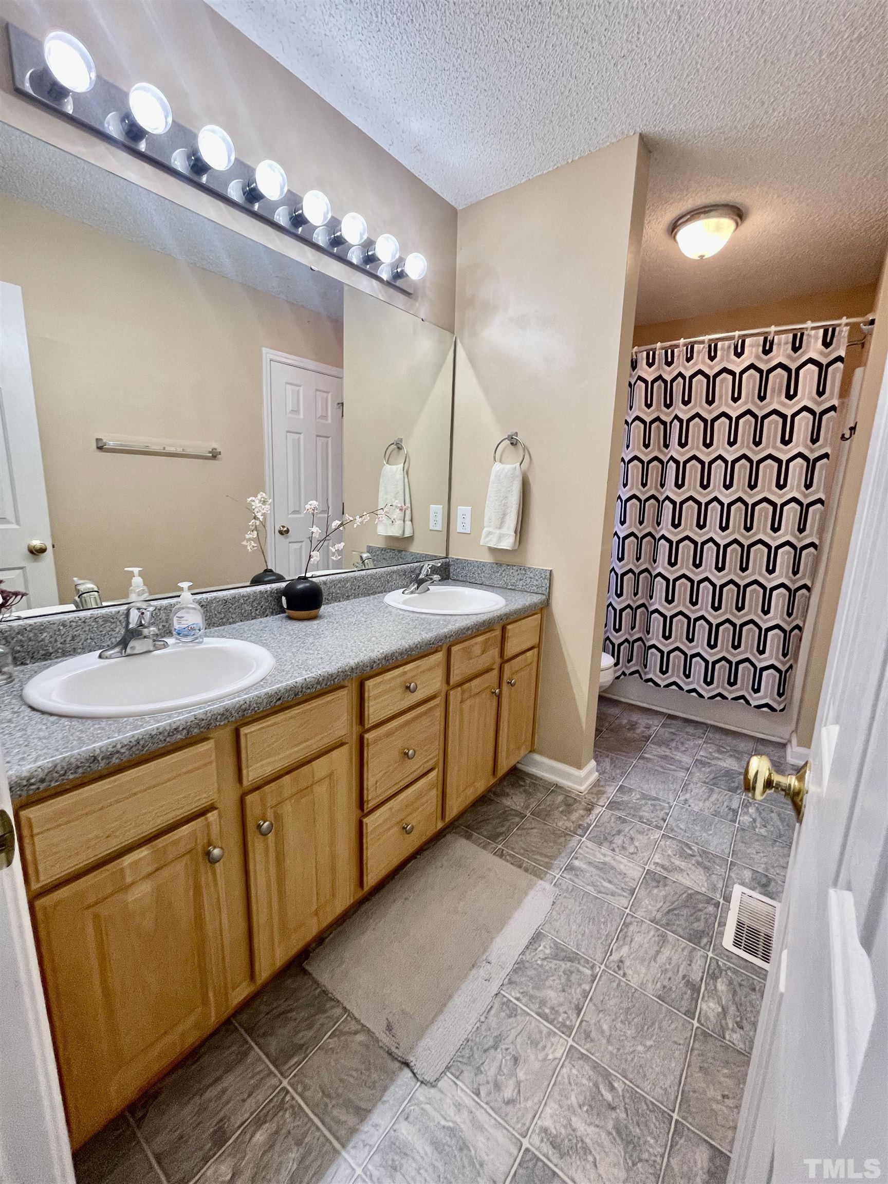 6105 Ruddington Court Willow Spring, NC 27592 - Photo 8 of 18 a bathroom with a double vanity sink mirror and double